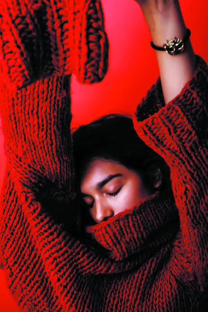 Jeune fille avec un pull rouge sur fond rouge